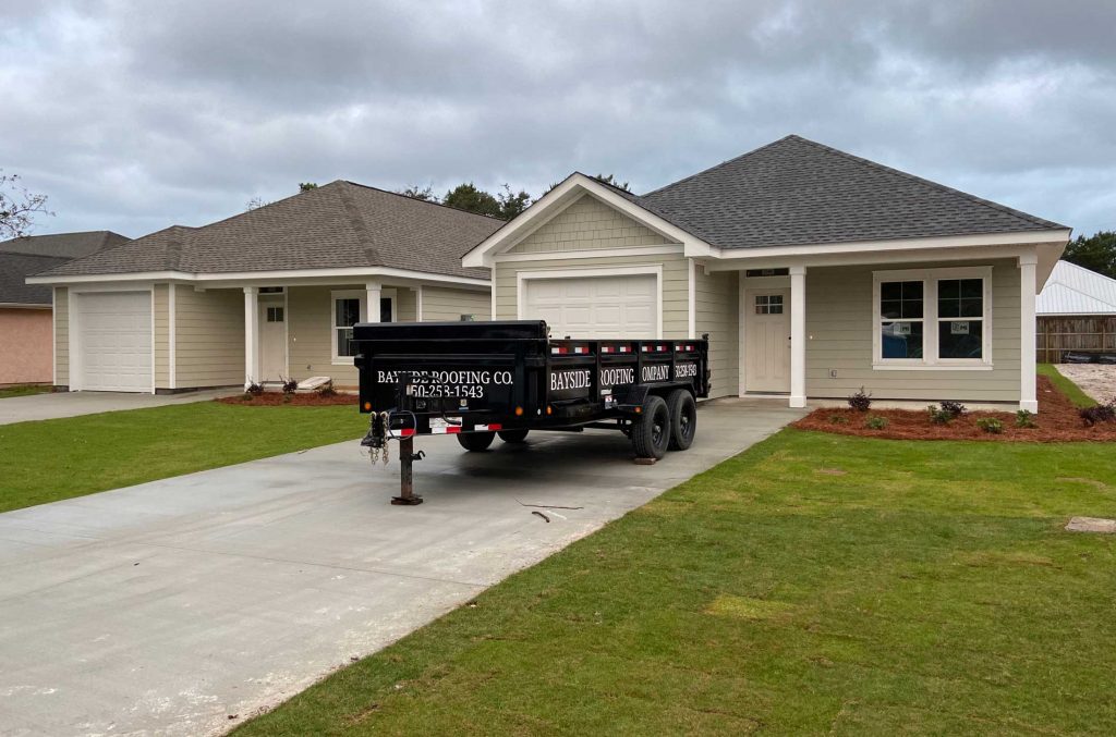 A cute Florida style home with a new asphalt roof and our trailer out front.